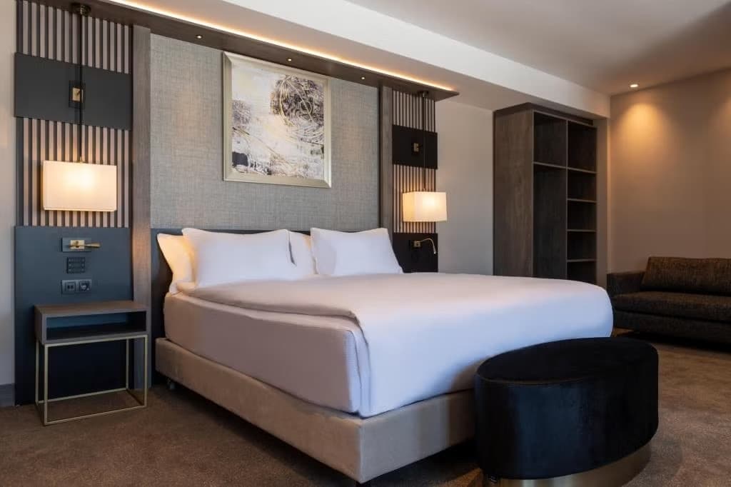 Otel odası — geniş yatak ve oturma köşesi